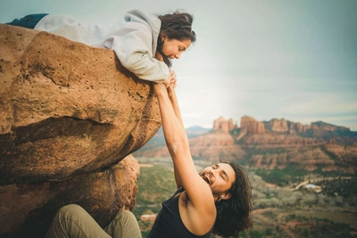 Happy man hanging on rock